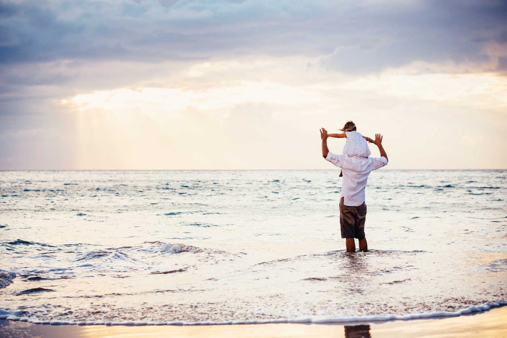 father and daughter playing together at the beach