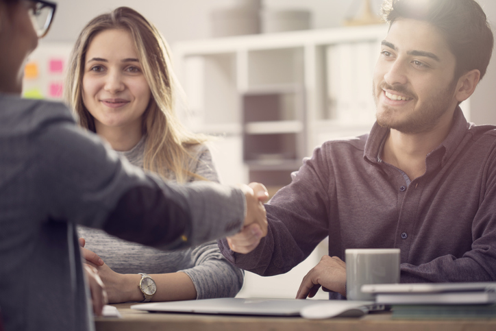 couple shaking hands with lawyer, smiling. concept for no fault divorce