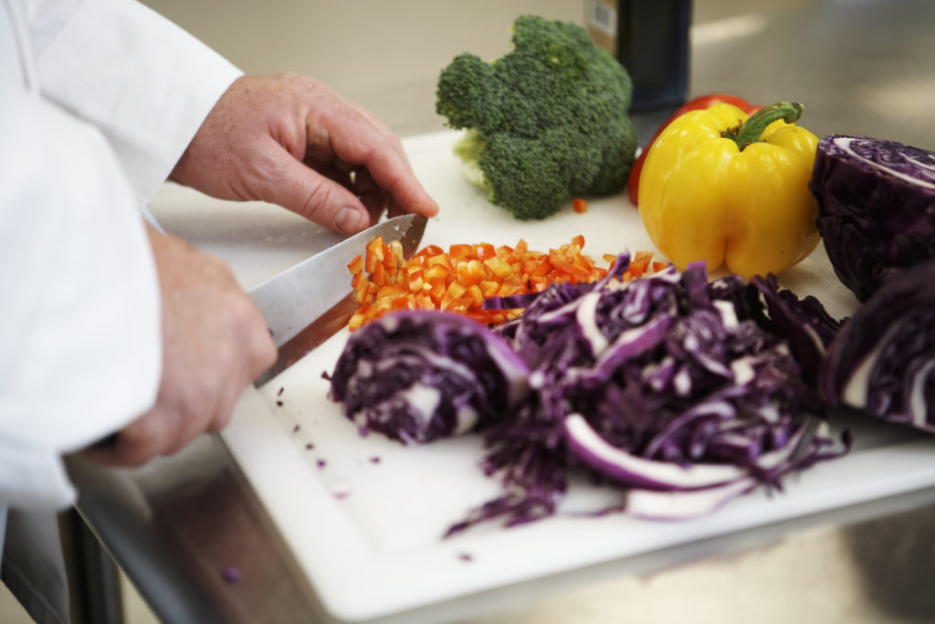 Chef chopping vegetables in kitchen, close-up