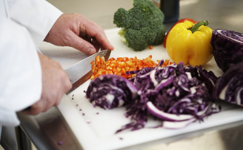 Chef chopping vegetables in kitchen, close-up