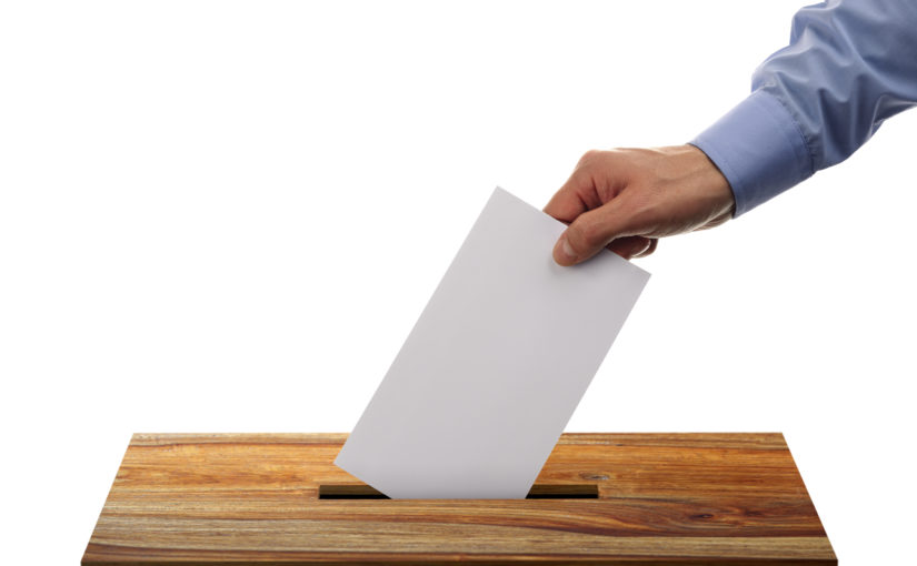 Ballot box with person casting vote on blank voting slip