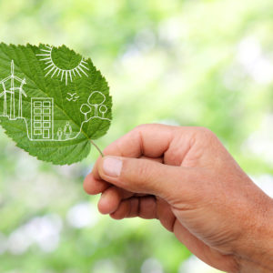 Hand holding a leaf with a Green city concept overlaid