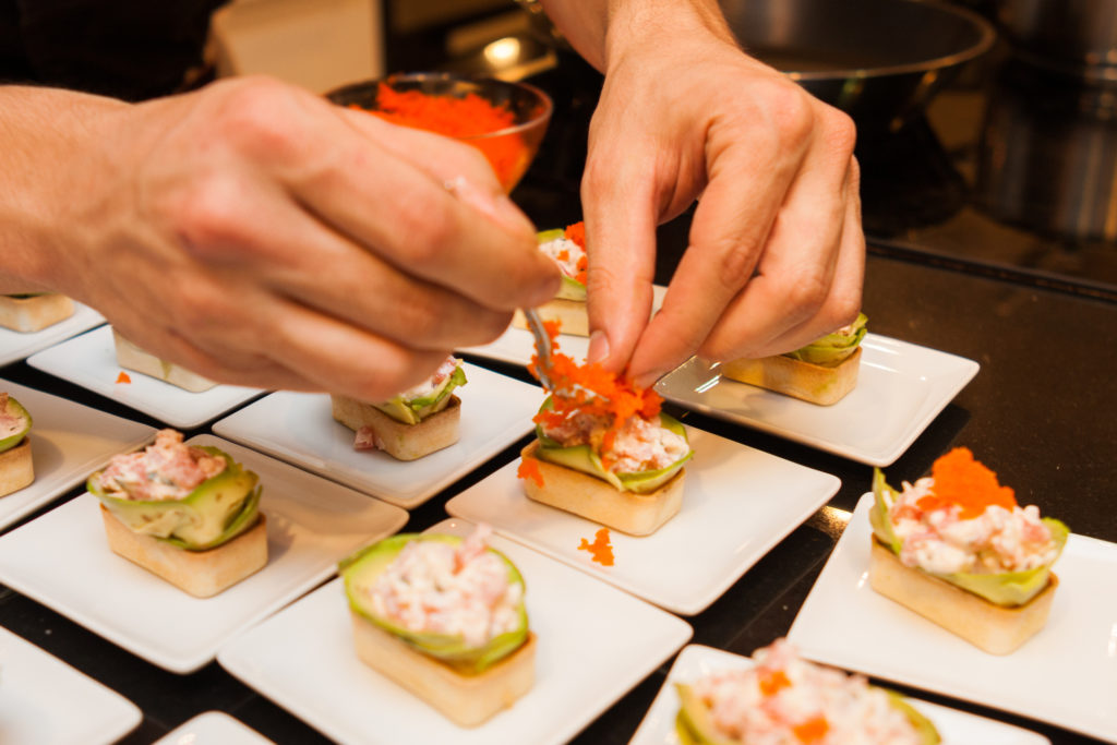 cook prepared delicious gourmet canapé starters on white plates