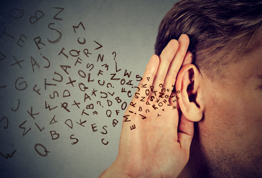 man holds his hand near ear and listens carefully alphabet letters flying