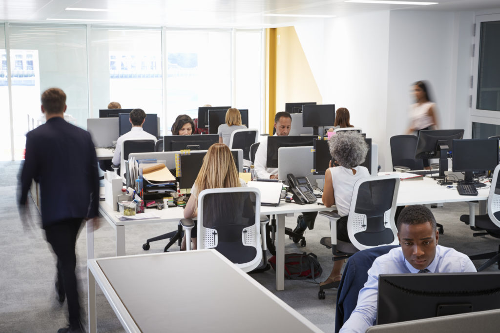 Man walking through a busy open plan office