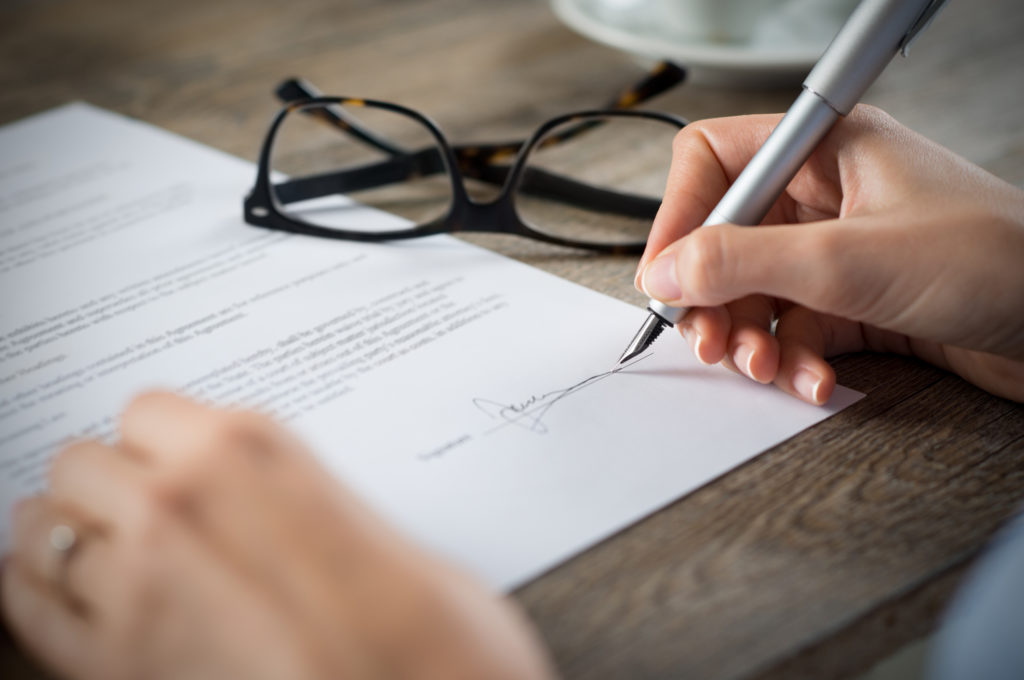 man signing a contract