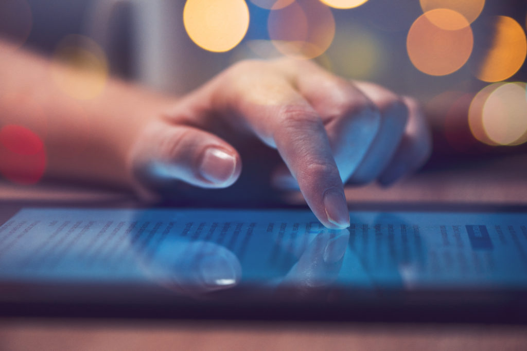 Woman's handing scrolling on a tablet