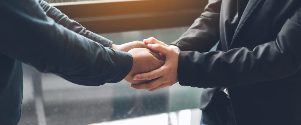 Business people compassionately holding hands at office room.