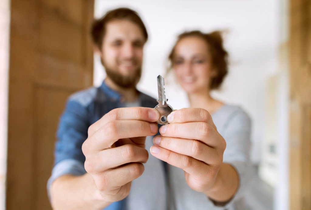 Couple with a key moving into their new house.