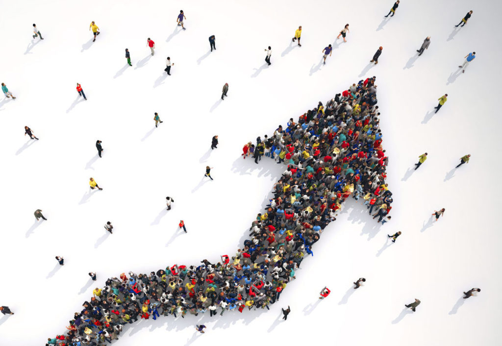 Crowds of people form an arrow going upwards