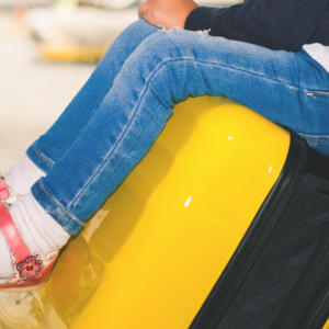photo of a child sitting on airport luggage