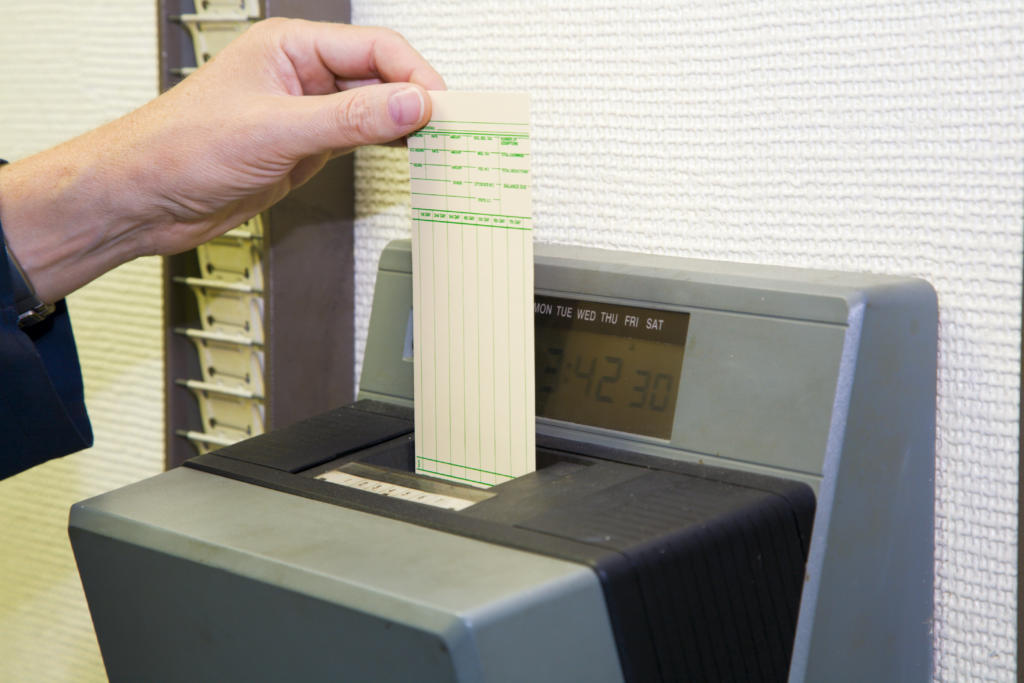 worker punching his time card with the automatic clock