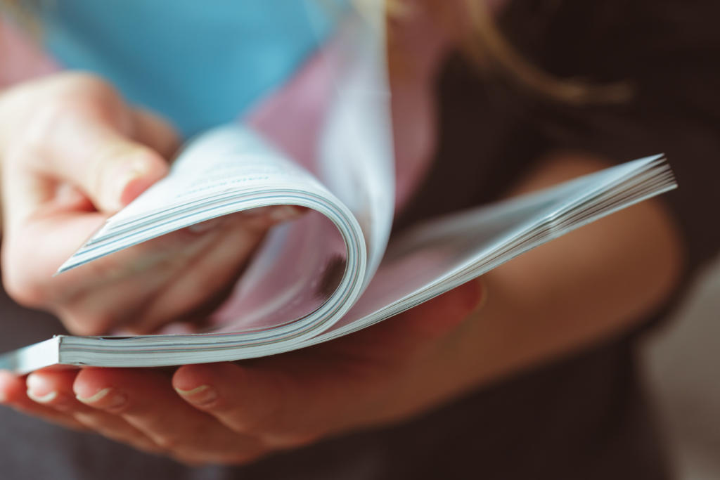 Woman flipping through magazine pages