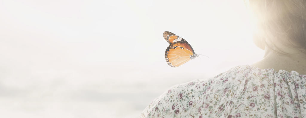 a colorful butterfly leans delicately on the shoulders of a girl