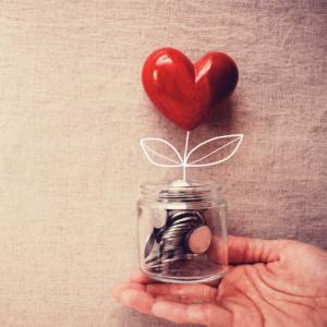 heart pebble in glass jar of coins