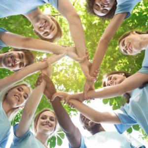 a group of happy volunteers outside linking hands