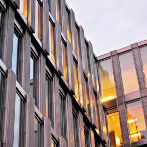 New office building in business center. Wall made of steel and glass with blue sky.