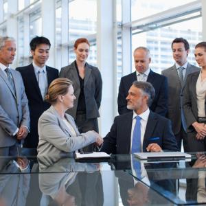 business acquisition people shaking hands in conference room following National Security and Investment Act 2021