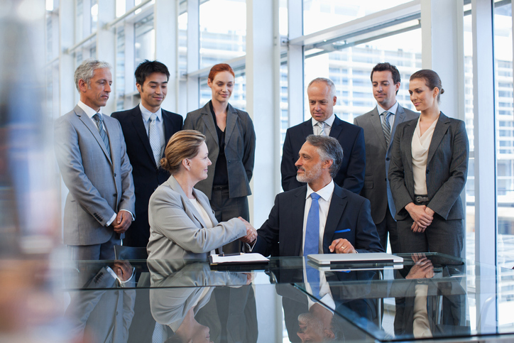 business acquisition people shaking hands in conference room following National Security and Investment Act 2021