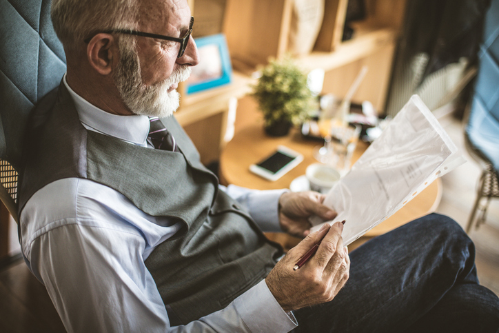 inheritance act claim time limit - older man sitting in a chair reviewing document for a Inheritance 1975 Act claim