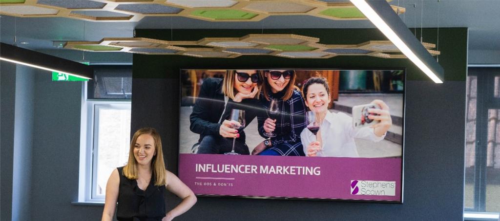 woman stands in front of Stephens Scown influencer marketing banner