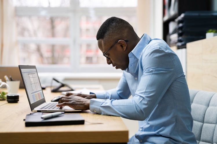 person works on intellectual property audit on laptop