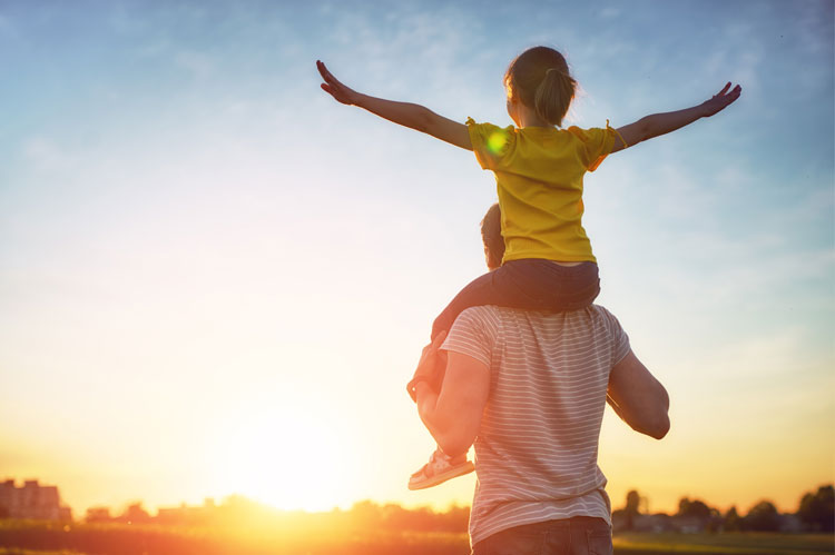 provide contact with child who sits on adults shoulders looking to sunset