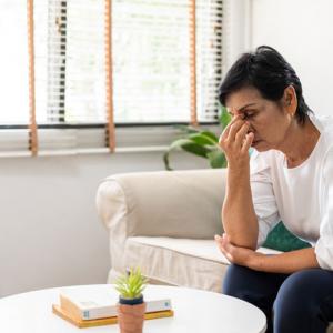 person sitting on sofa concerned about unfair pension distribution in divorce