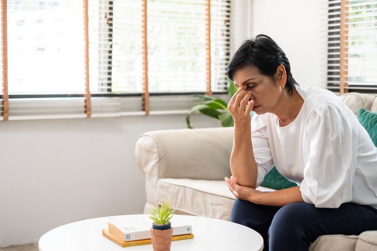 person sitting on sofa concerned about unfair pension distribution in divorce