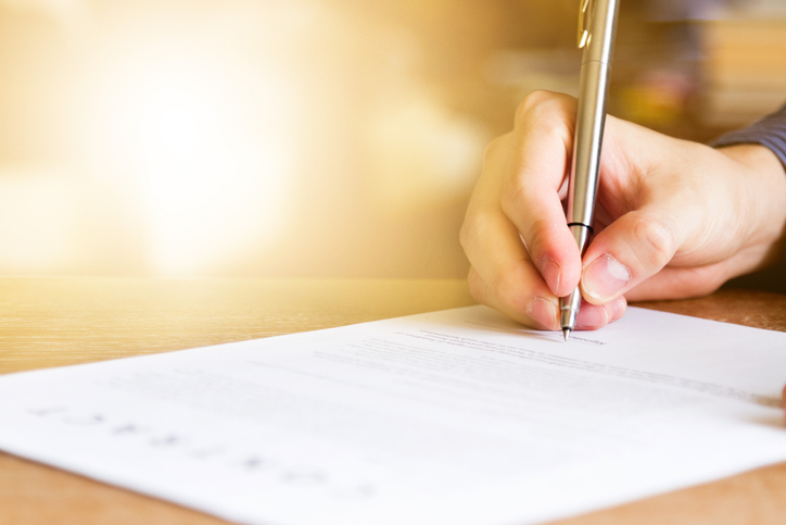 Hand with pen, signing a contract