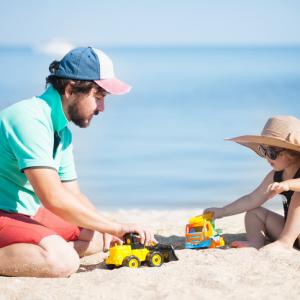 how to split school holidays when divorced - dad with young daughter on beach enjoying school holidays