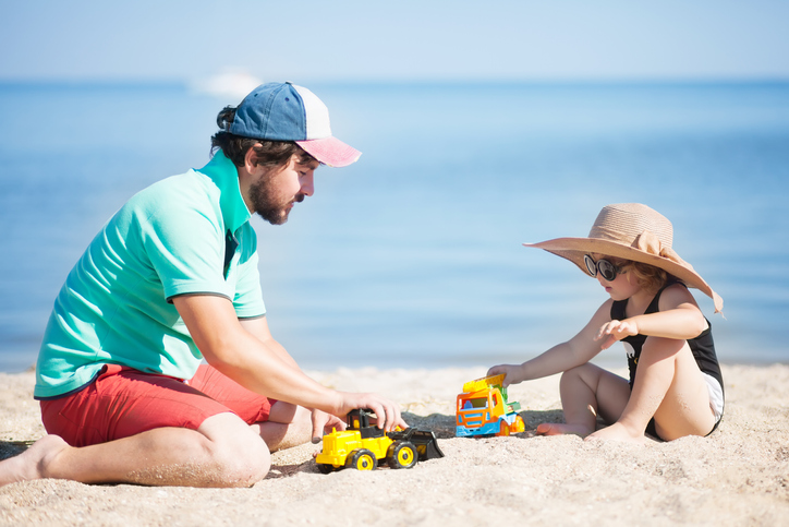 how to split school holidays when divorced - dad with young daughter on beach enjoying school holidays