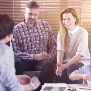 divorced parents meeting with a teacher, happily working together and successfully co-parenting