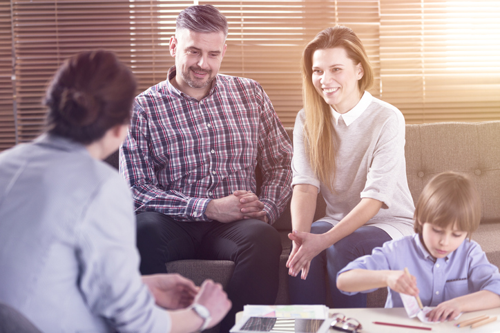 divorced parents meeting with a teacher, happily working together and successfully co-parenting