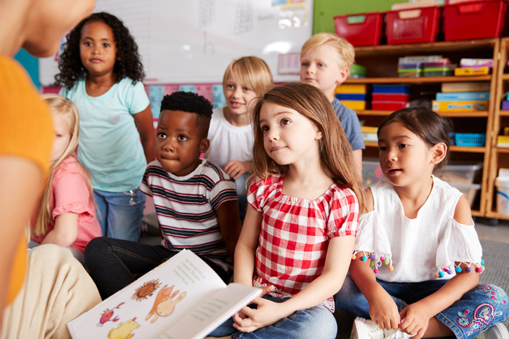 teacher reading a story to children. concept for parental consent for activities and lessons at school