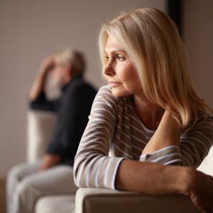 woman and man sitting apart on sofa - concept for no fault divorce