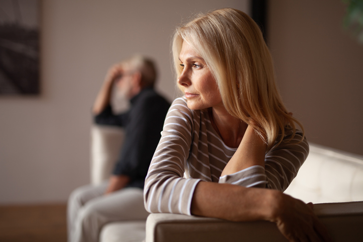 woman and man sitting apart on sofa - concept for no fault divorce