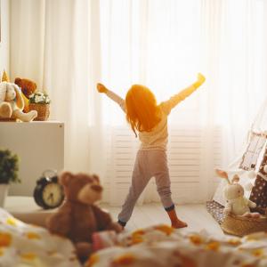 morning, child waking up and stretching in bedroom. concept for children having separate bedrooms