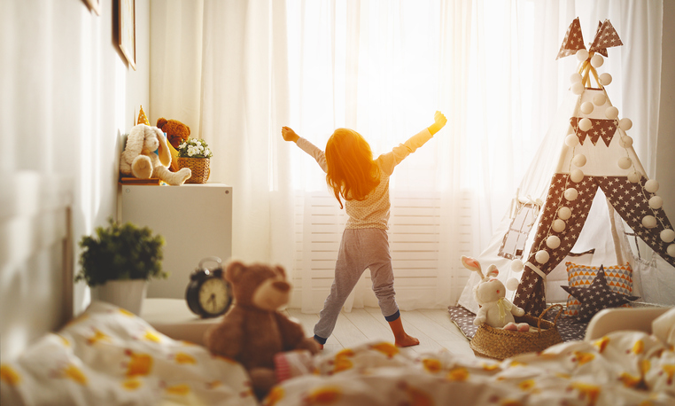 morning, child waking up and stretching in bedroom. concept for children having separate bedrooms