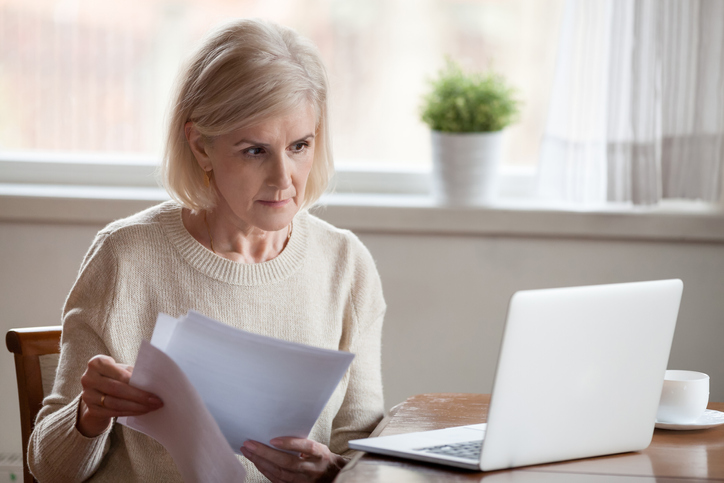 older woman at laptop, going through pensions, working out overseas pensions