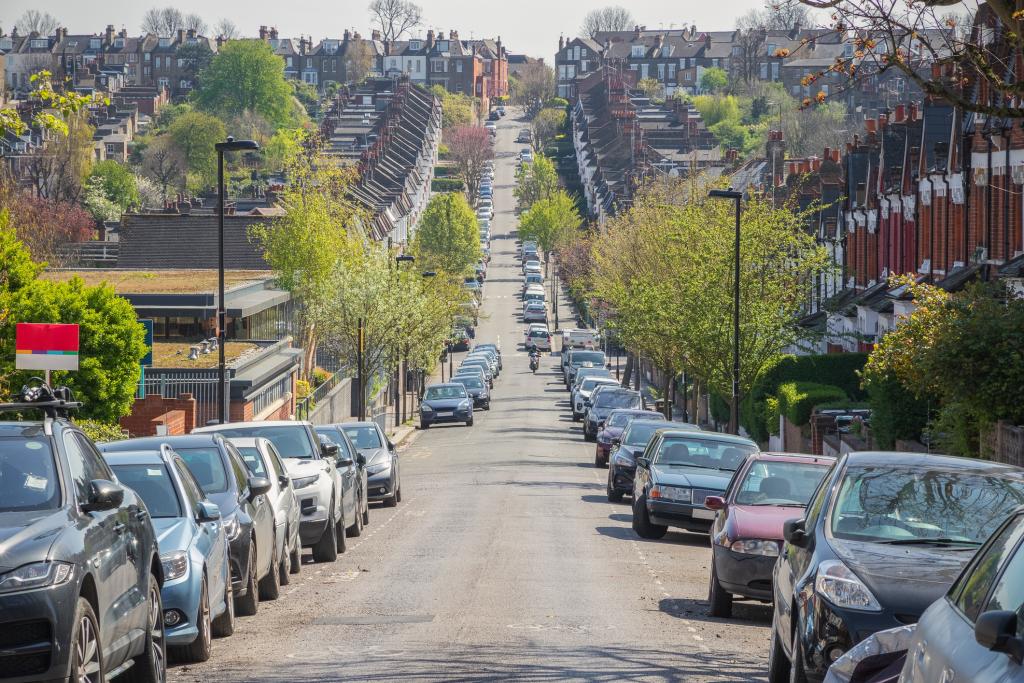 Typical London street lined with terraced houses and parked cars around Crouch End area