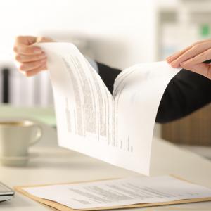 woman ripping up a piece of paper with typed writing on it. concept image to show that wills can be revoked