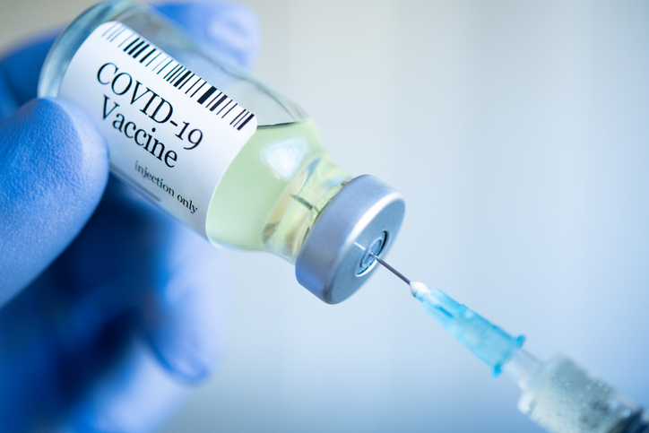 bottle of covid-19 vaccination with needle being inserted into it. concept image for mandatory vaccinations