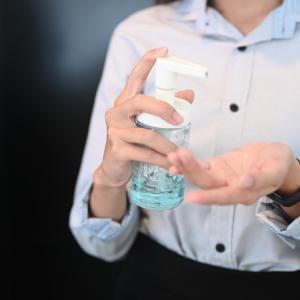 business person using hand sanitizer. concept for living with covid