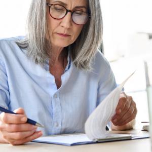 Older woman reviewing document. Concept for updating Wills