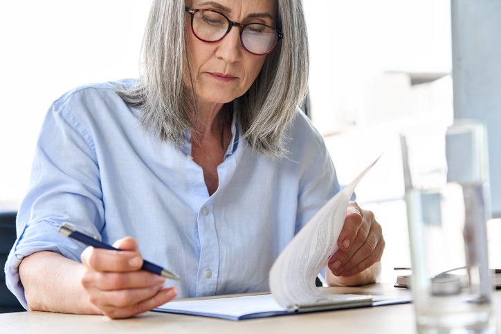 Older woman reviewing document. Concept for updating Wills