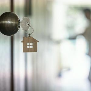 key with metal house ornament hanging from open door