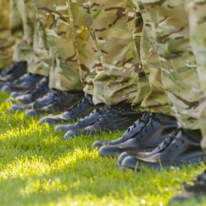line of feet wearing military boots and camo trousers. concept for armed forces pension
