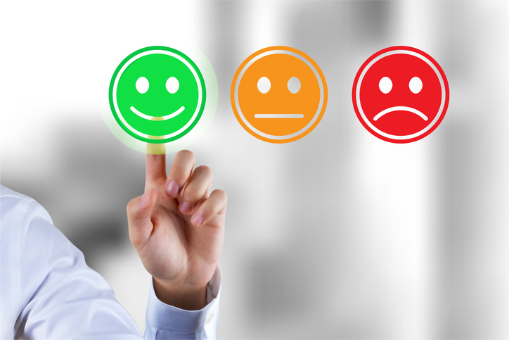 finger pointing to illustration of a green smiley, not the orange or red sad smileys, indicating happy customer and good client service