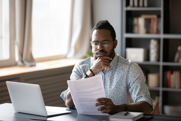 smartly dressed man looking at draft consent order, thoughtful